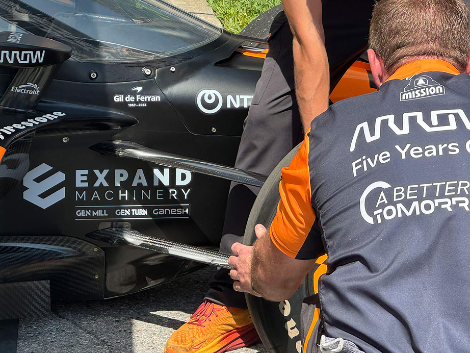 Orange and black nascar with an expand machinery sponsorship logo