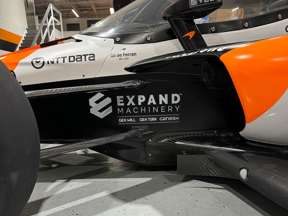 Orange and black nascar with an expand machinery sponsorship logo